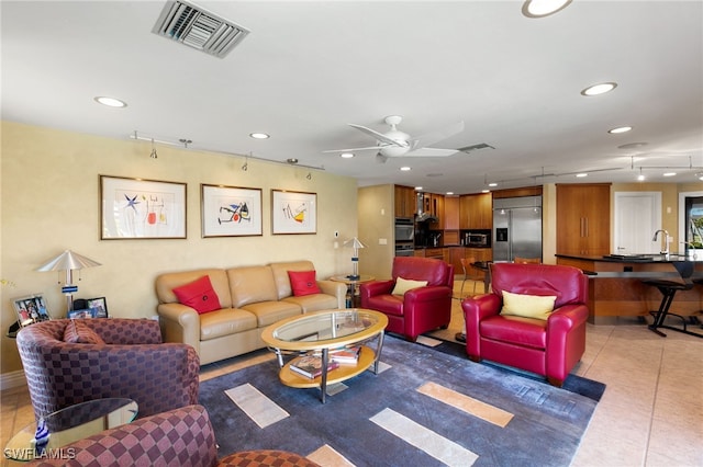 living room with tile patterned floors, ceiling fan, and sink