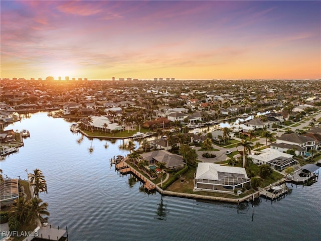 aerial view at dusk featuring a water view