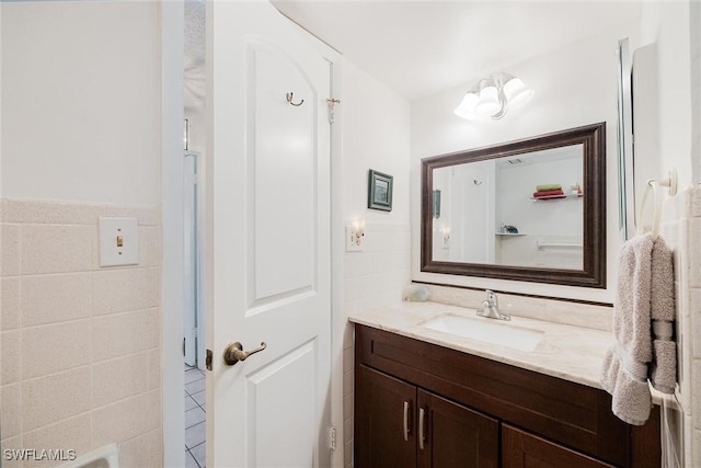 bathroom featuring vanity and tile walls