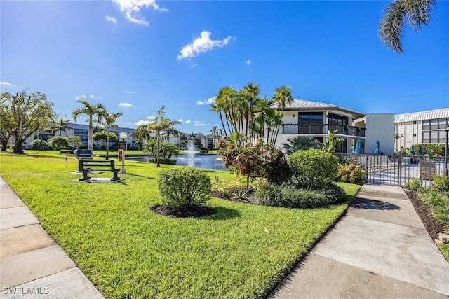 view of community with a yard and a water view