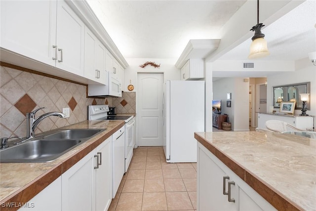 kitchen featuring white cabinetry, sink, decorative light fixtures, and white appliances