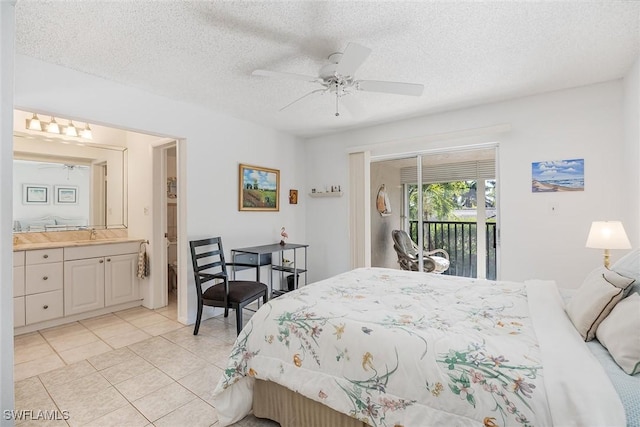 tiled bedroom featuring a textured ceiling, access to outside, ceiling fan, sink, and connected bathroom