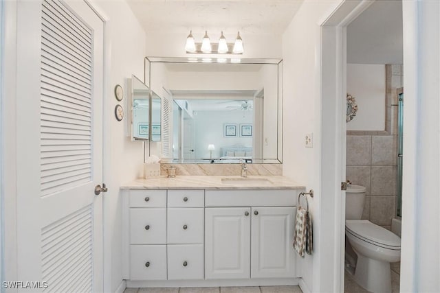 bathroom featuring vanity, ceiling fan, tile walls, tile patterned flooring, and toilet