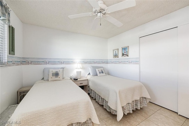 tiled bedroom featuring ceiling fan and a textured ceiling