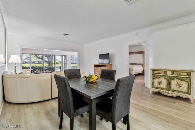 dining room featuring light hardwood / wood-style floors and ornamental molding