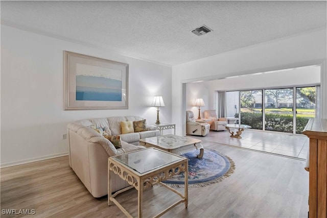 living room with light hardwood / wood-style floors and a textured ceiling