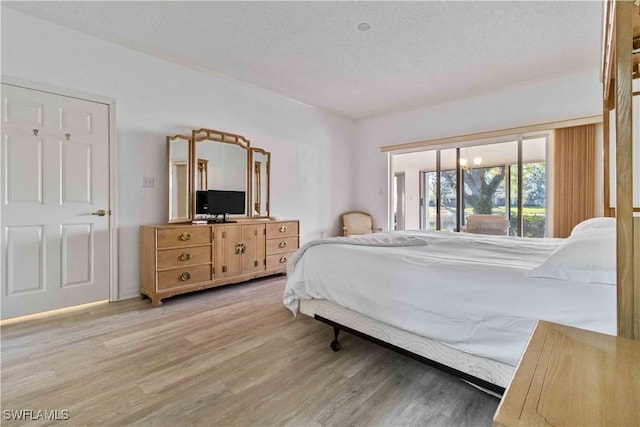 bedroom with a textured ceiling and light hardwood / wood-style floors