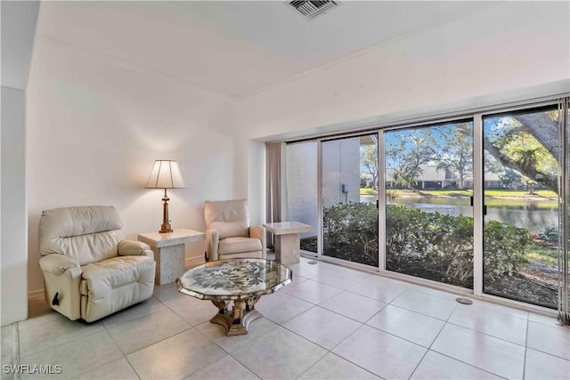 living area with a water view and light tile patterned floors