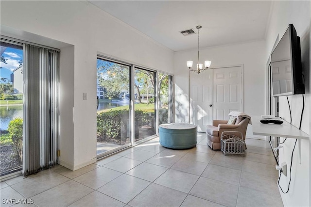 living area with a water view, light tile patterned floors, and an inviting chandelier