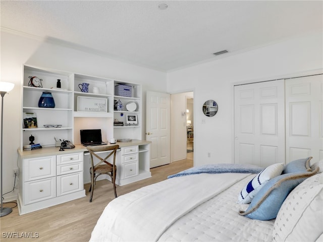 808 Arbor Lake Dr Unit 8-105, Naples, FL 34110 - bedroom with light wood-style flooring, a closet, ornamental molding, and a textured ceiling