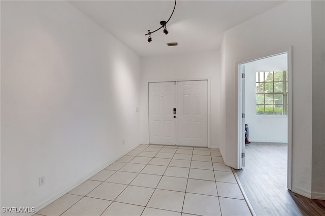 entryway with rail lighting and light hardwood / wood-style flooring