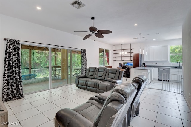 tiled living room with ceiling fan, plenty of natural light, and sink