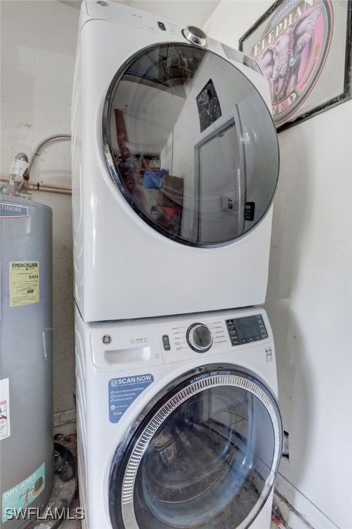 washroom featuring stacked washer / dryer and water heater