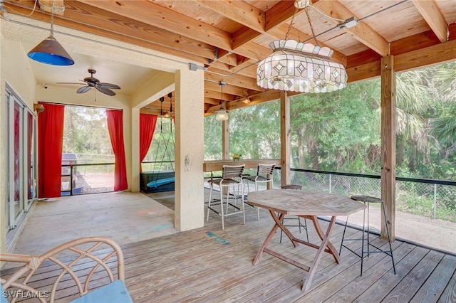 unfurnished sunroom featuring beamed ceiling, ceiling fan, and wood ceiling