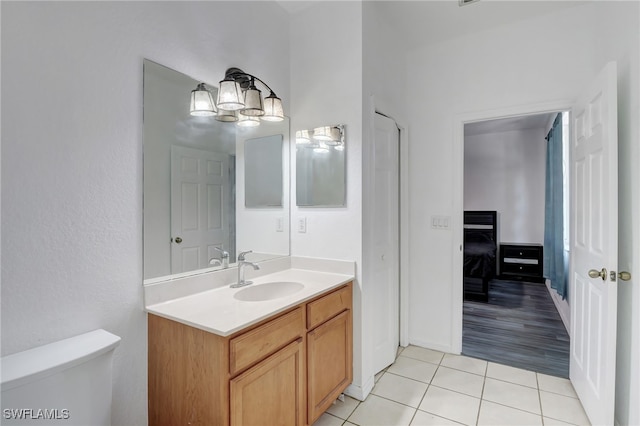 bathroom featuring toilet, vanity, a notable chandelier, and hardwood / wood-style flooring