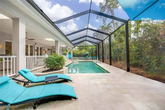 view of pool with ceiling fan, a lanai, and a patio