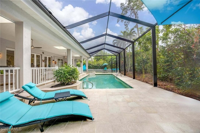 view of swimming pool featuring a patio, ceiling fan, and glass enclosure