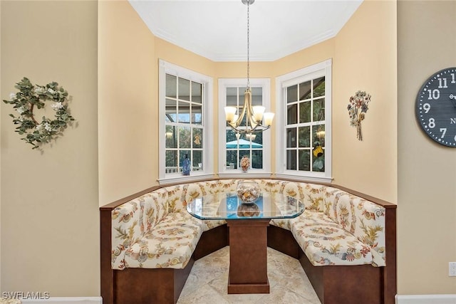 dining area with breakfast area, crown molding, and an inviting chandelier