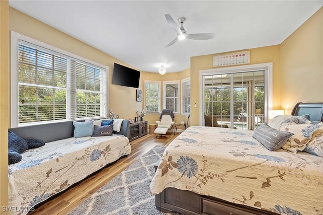 bedroom featuring ceiling fan, wood-type flooring, and access to outside