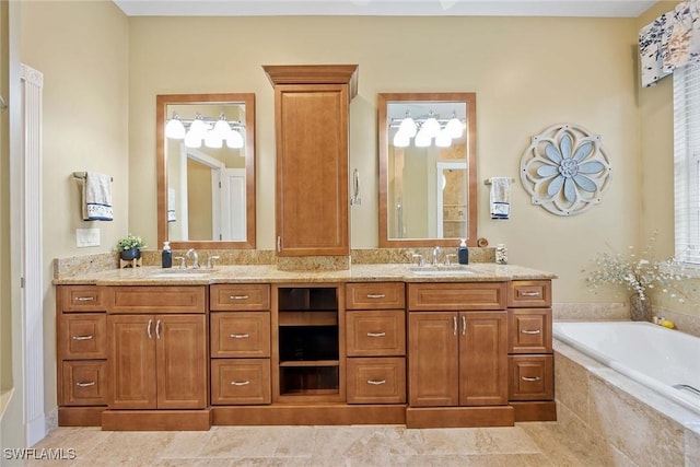 bathroom with tiled bath, vanity, and tile patterned flooring