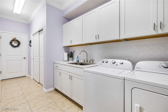 washroom featuring washer and clothes dryer, cabinets, sink, light tile patterned floors, and ornamental molding