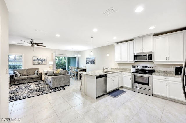 kitchen with white cabinets, kitchen peninsula, hanging light fixtures, and appliances with stainless steel finishes