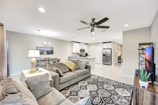 living room with light tile patterned floors and ceiling fan with notable chandelier