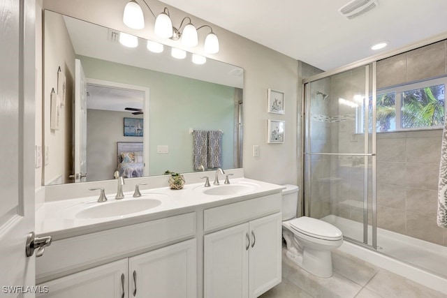 bathroom featuring tile patterned floors, vanity, a shower with shower door, and toilet