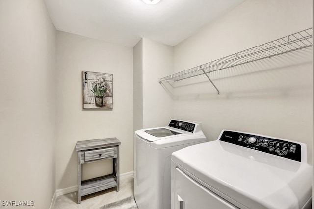 laundry area featuring light tile patterned floors and washer and dryer