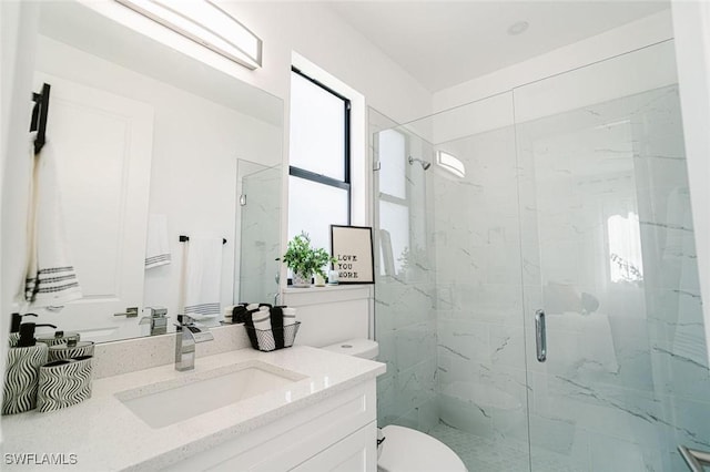 bathroom featuring vanity, toilet, and a shower with shower door