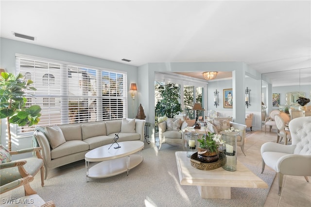 living room with light tile patterned floors, a wealth of natural light, and an inviting chandelier