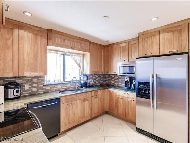 kitchen featuring tasteful backsplash, sink, light tile patterned flooring, and appliances with stainless steel finishes