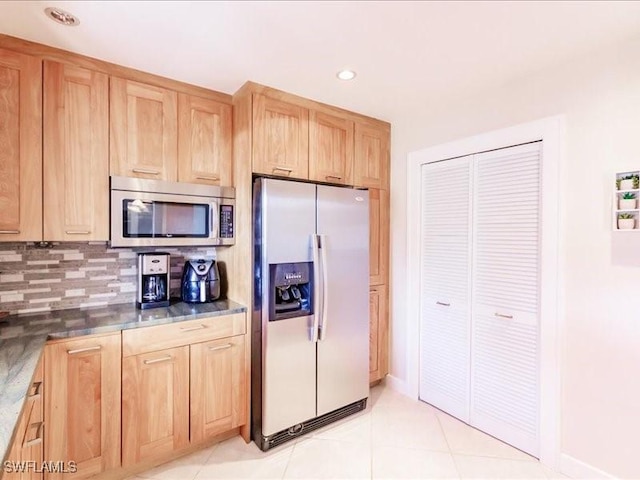 kitchen featuring decorative backsplash, light brown cabinetry, light tile patterned flooring, and stainless steel appliances