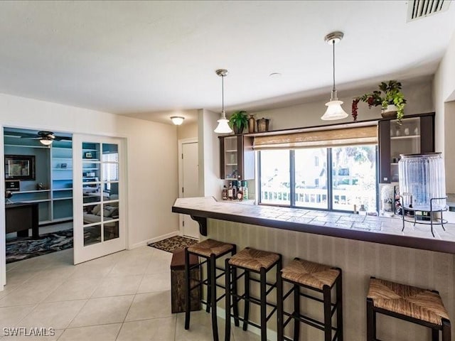 kitchen featuring a breakfast bar, pendant lighting, and light tile patterned floors