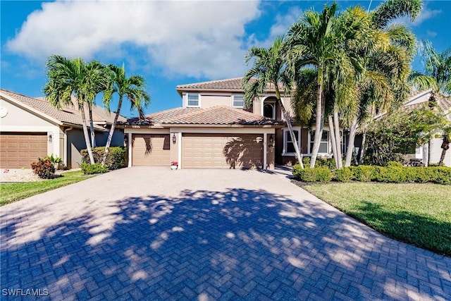 mediterranean / spanish-style house featuring a garage and a front lawn