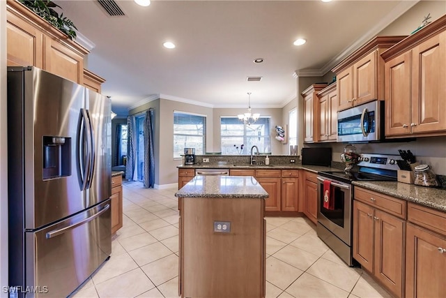 kitchen featuring stainless steel appliances, crown molding, stone counters, a chandelier, and a center island