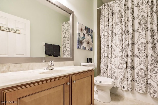 bathroom with toilet, vanity, and tile patterned floors