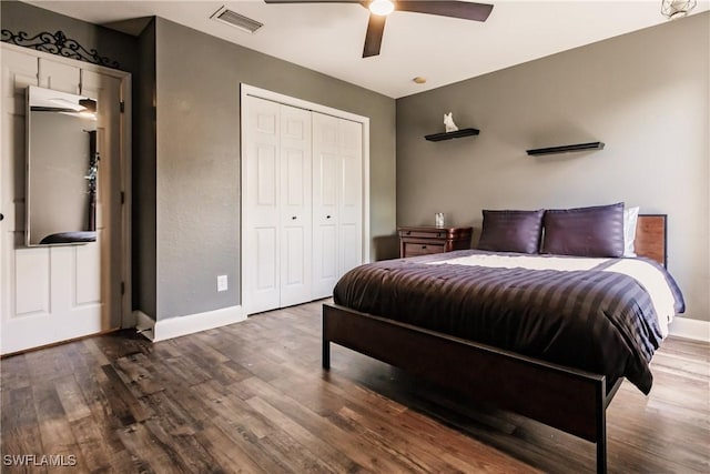 bedroom with ceiling fan, a closet, and dark wood-type flooring