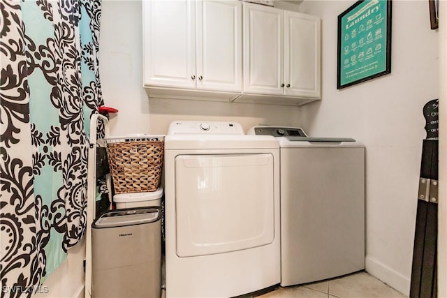 laundry room with light tile patterned floors, cabinets, and independent washer and dryer