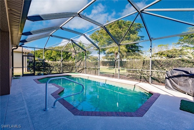 view of pool featuring glass enclosure and a patio area