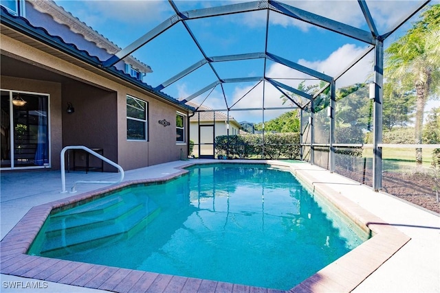 view of swimming pool with glass enclosure and a patio area