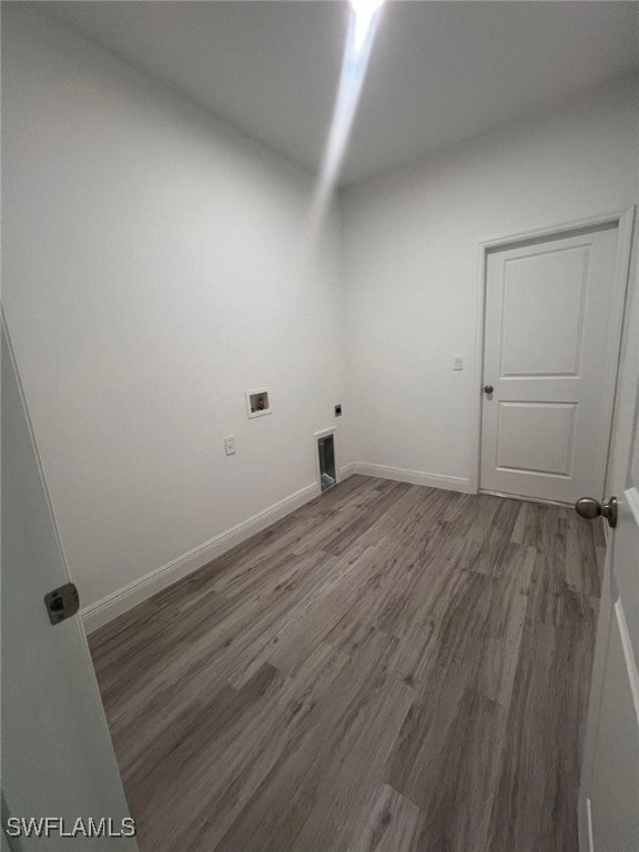 clothes washing area with electric dryer hookup, hookup for a washing machine, and hardwood / wood-style floors