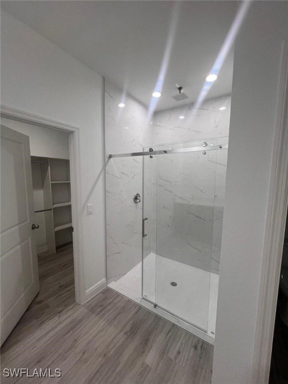 bathroom featuring hardwood / wood-style floors and a shower with door