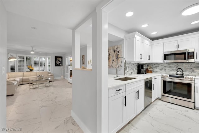 kitchen featuring stainless steel appliances, white cabinetry, ceiling fan, and sink