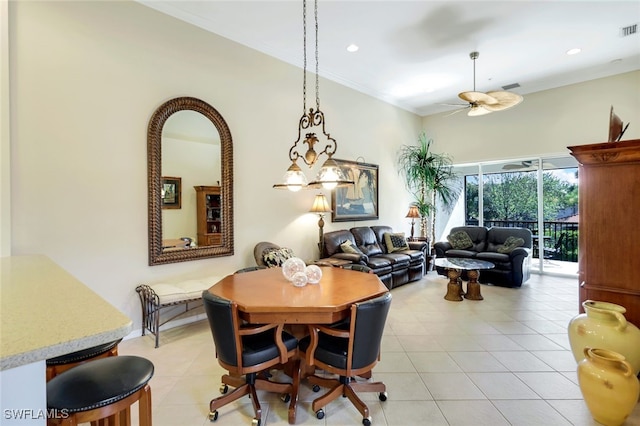 tiled dining room with ceiling fan and crown molding