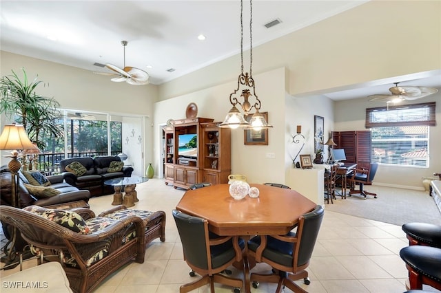 tiled dining space featuring ceiling fan, plenty of natural light, and crown molding