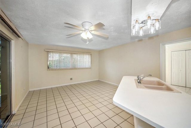 interior space with sink, light tile patterned flooring, and a textured ceiling