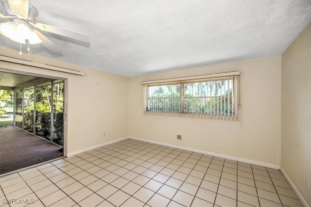 empty room featuring a textured ceiling, ceiling fan, and light tile patterned flooring