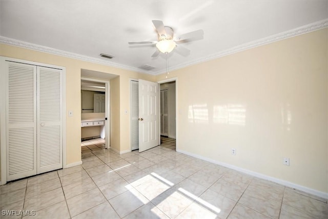 unfurnished bedroom with ceiling fan, light tile patterned floors, two closets, and ornamental molding