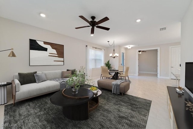 living room with ceiling fan with notable chandelier